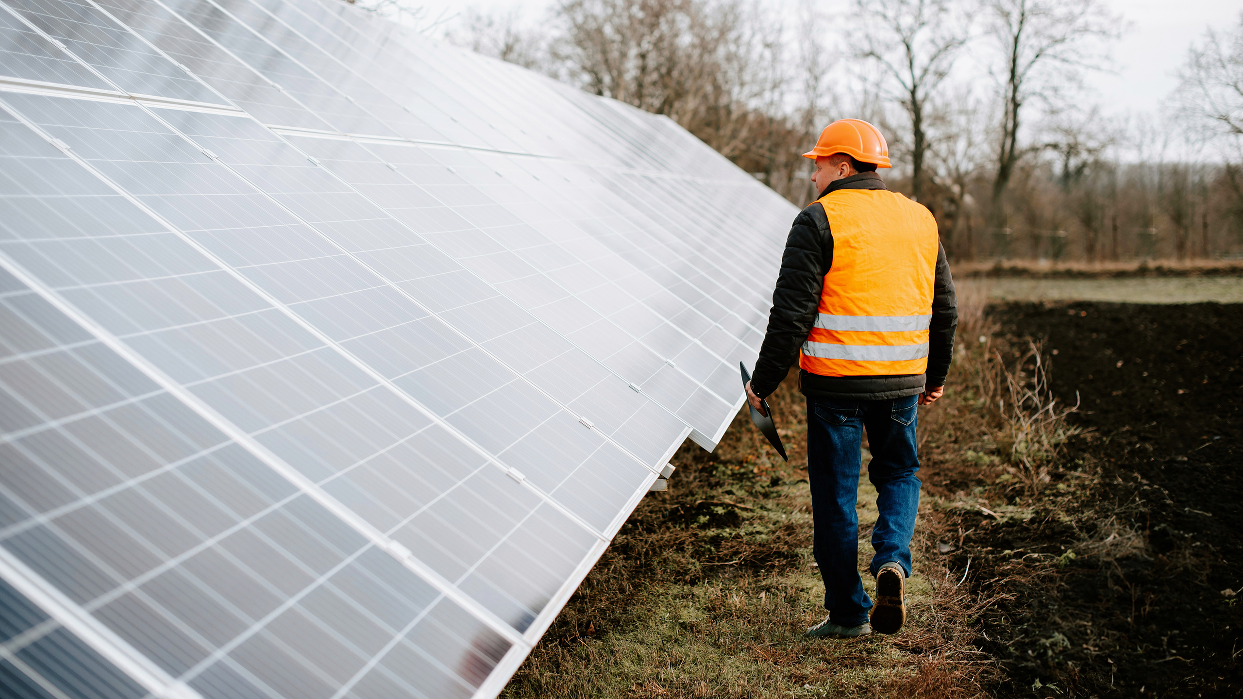 Photo of a worker next to solar panels