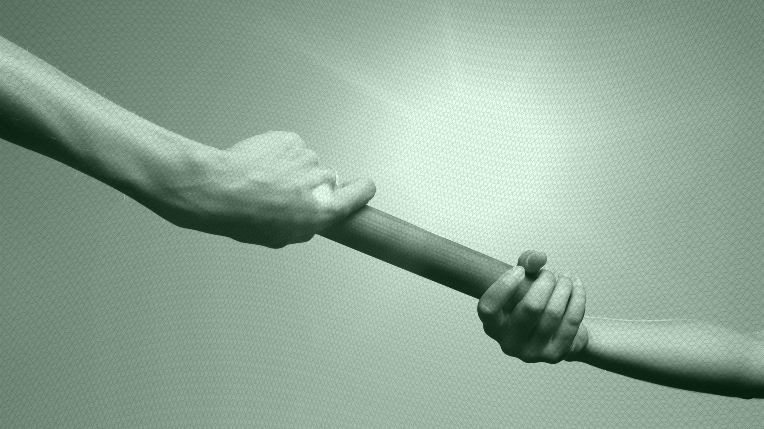 Photo of two people passing a baton