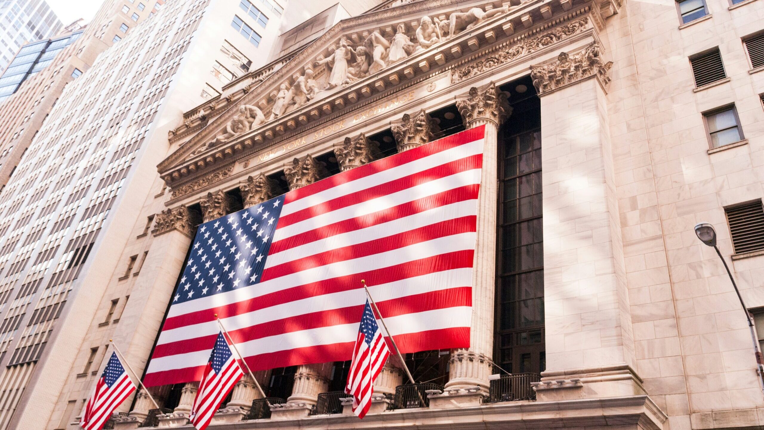 A large American flag hangs in front of the New York Stock Exchange in New York City.
