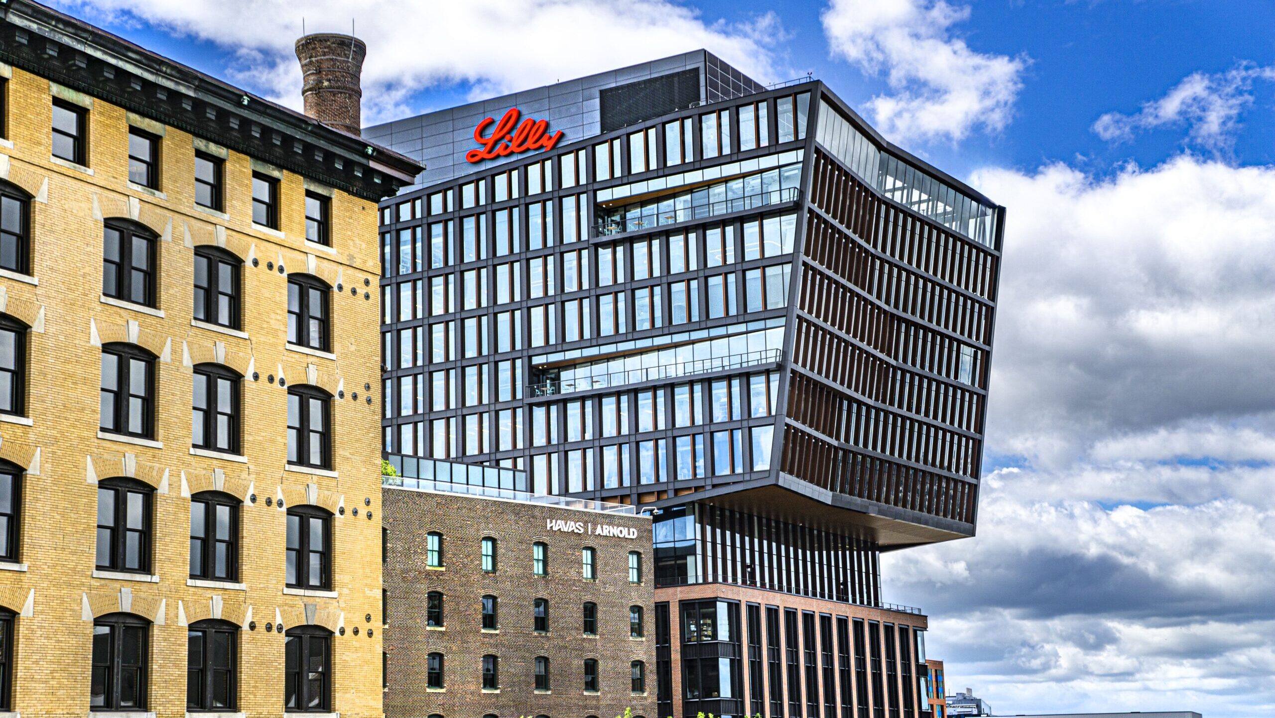 The exterior of the Lilly Seaport Innovation Center in Boston is shown against bright, cloudy sky.