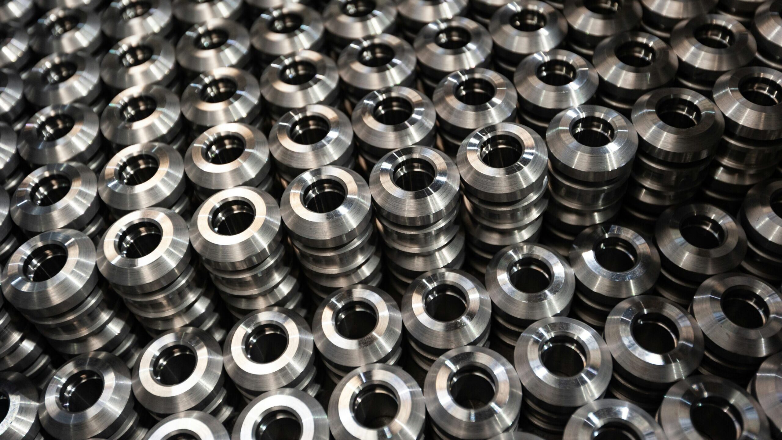 Several tightly packed stacks of metal flanges are shown up close.