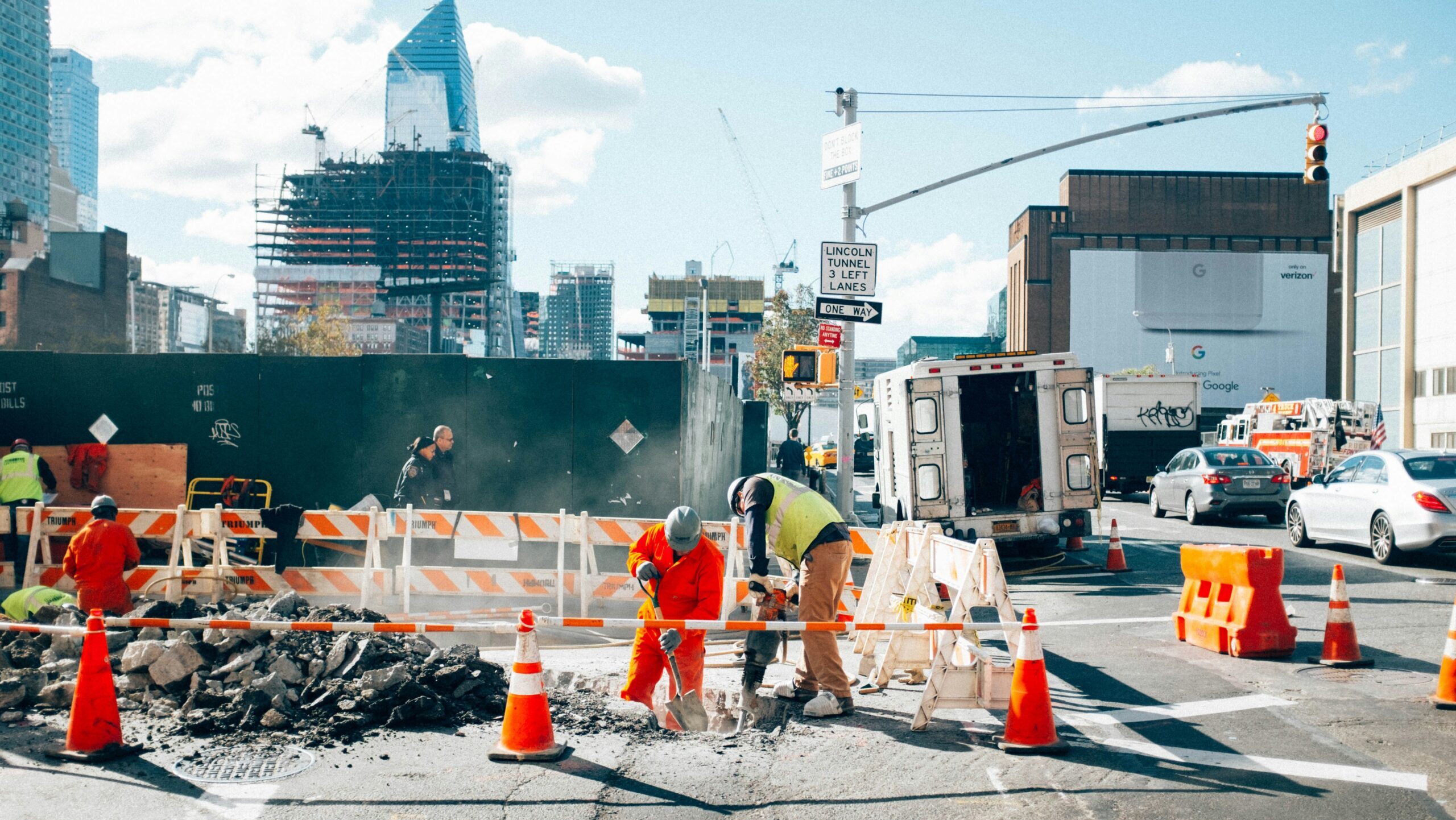 A group of construction workers are seen shoveling on a street in New York City.