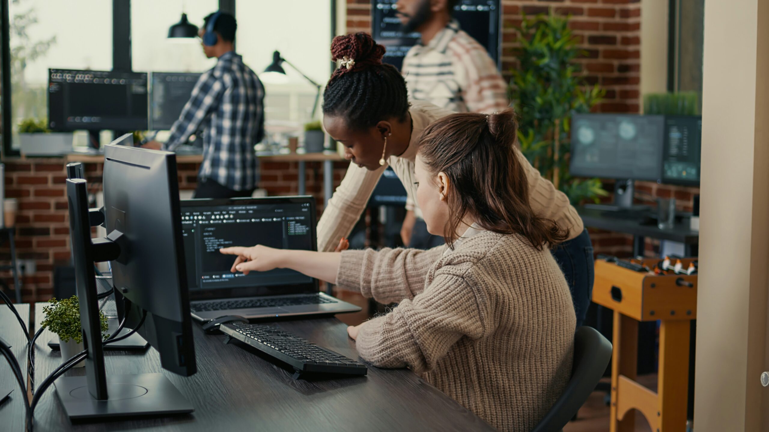 Photo of people looking at code on a computer
