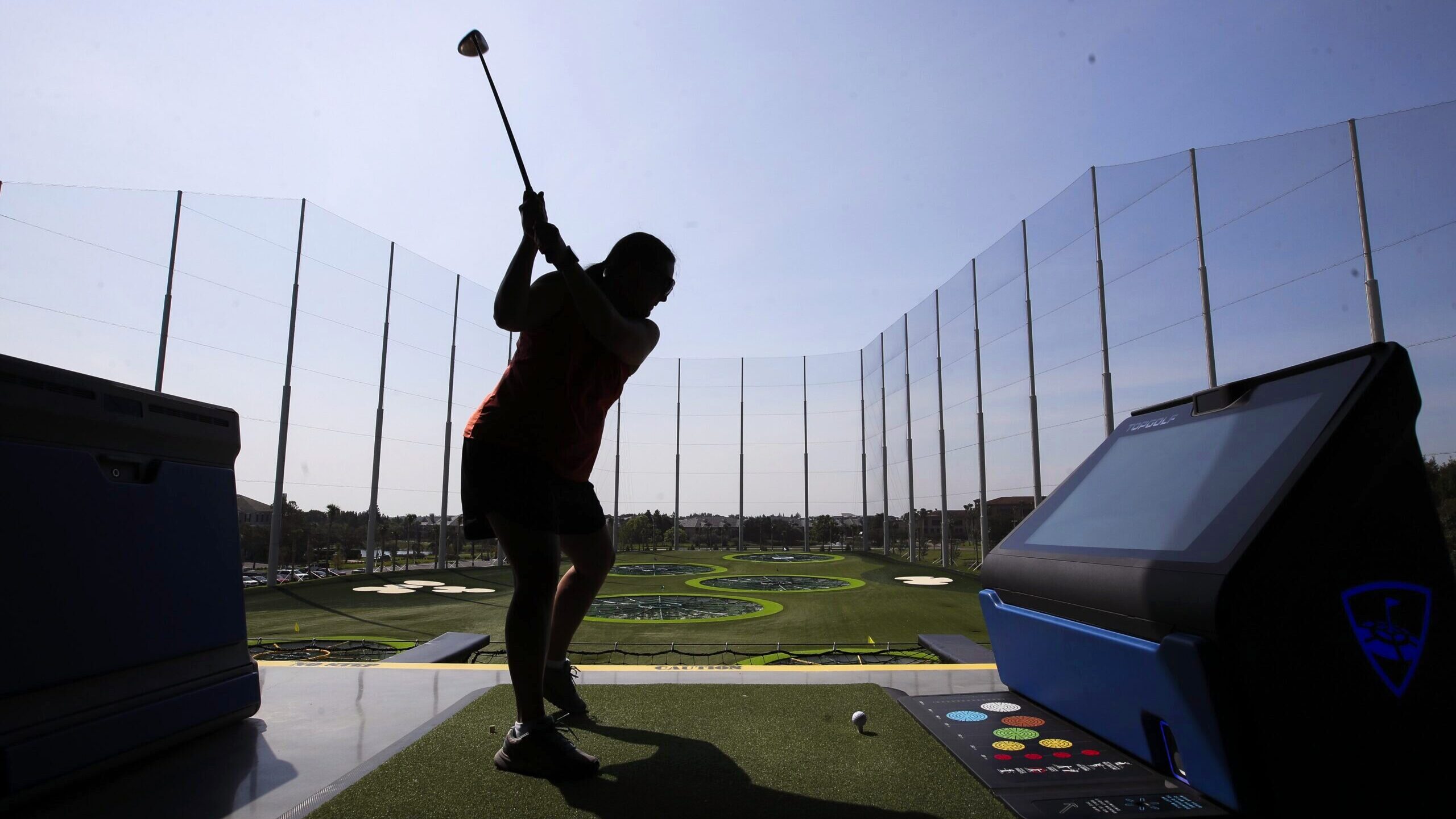 Photo of a guest teeing off at a Topgolf location.