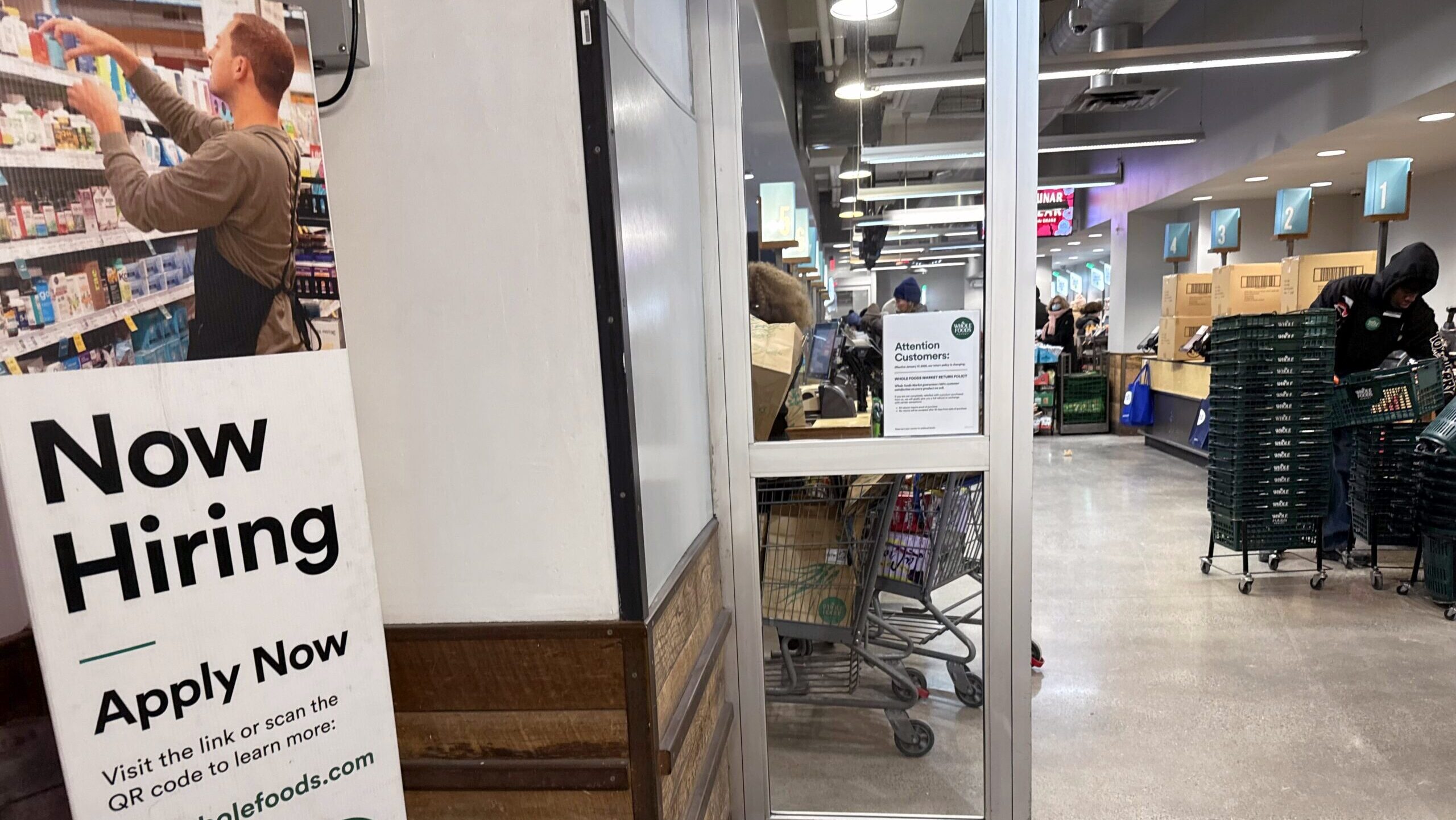Photo of a Now Hiring sign outside a Whole Foods.