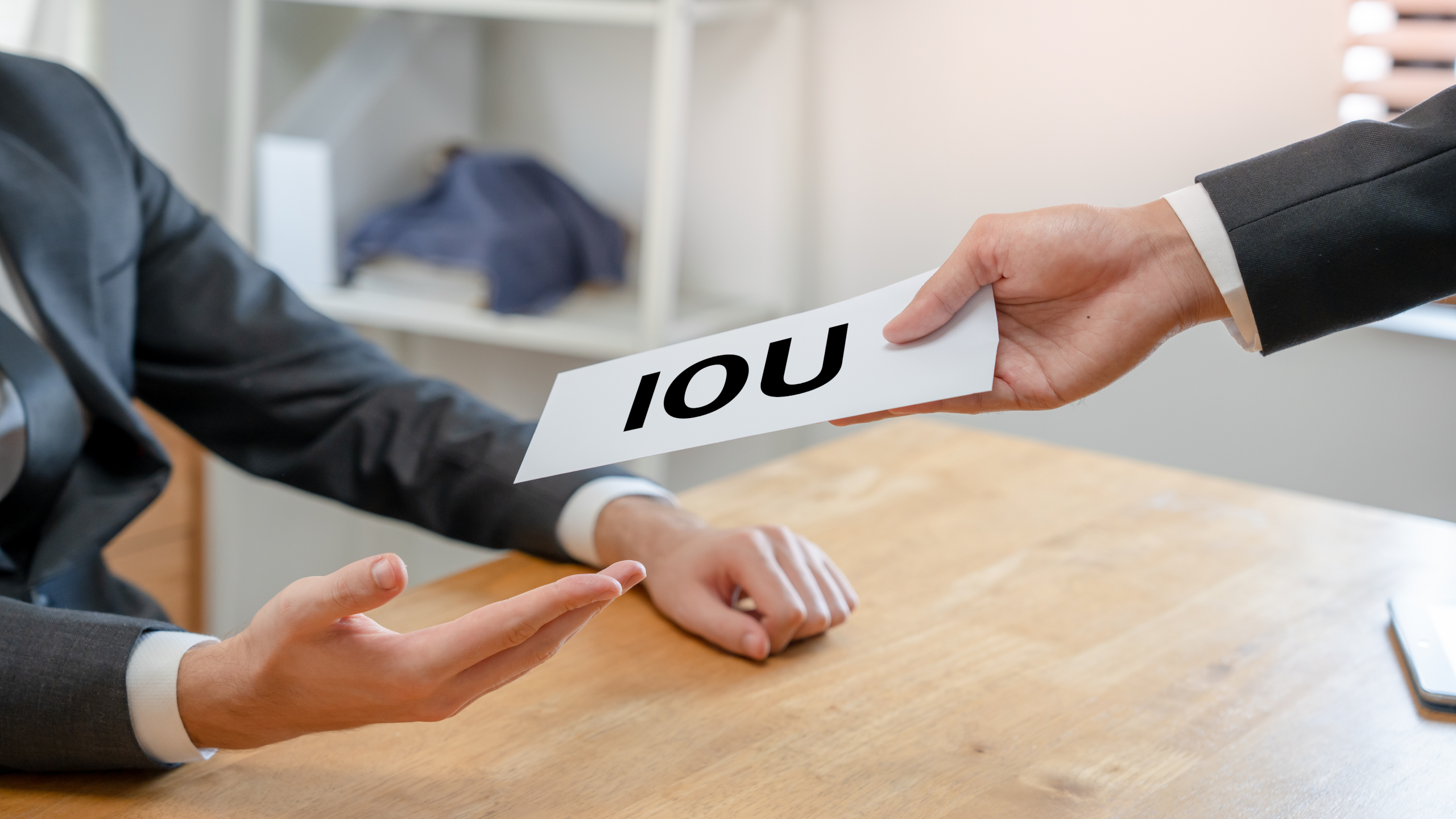 Photo of a person handing someone an IOU note