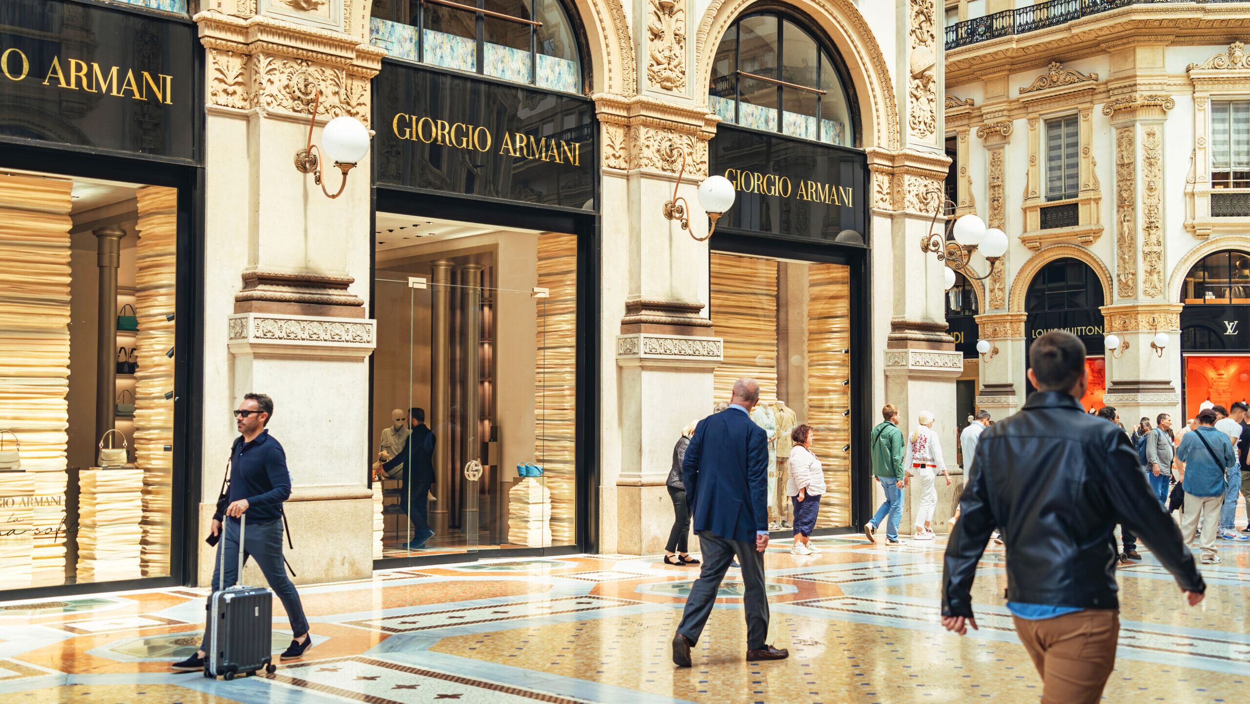 Photo of shoppers near a Giorgio Armani storefront.