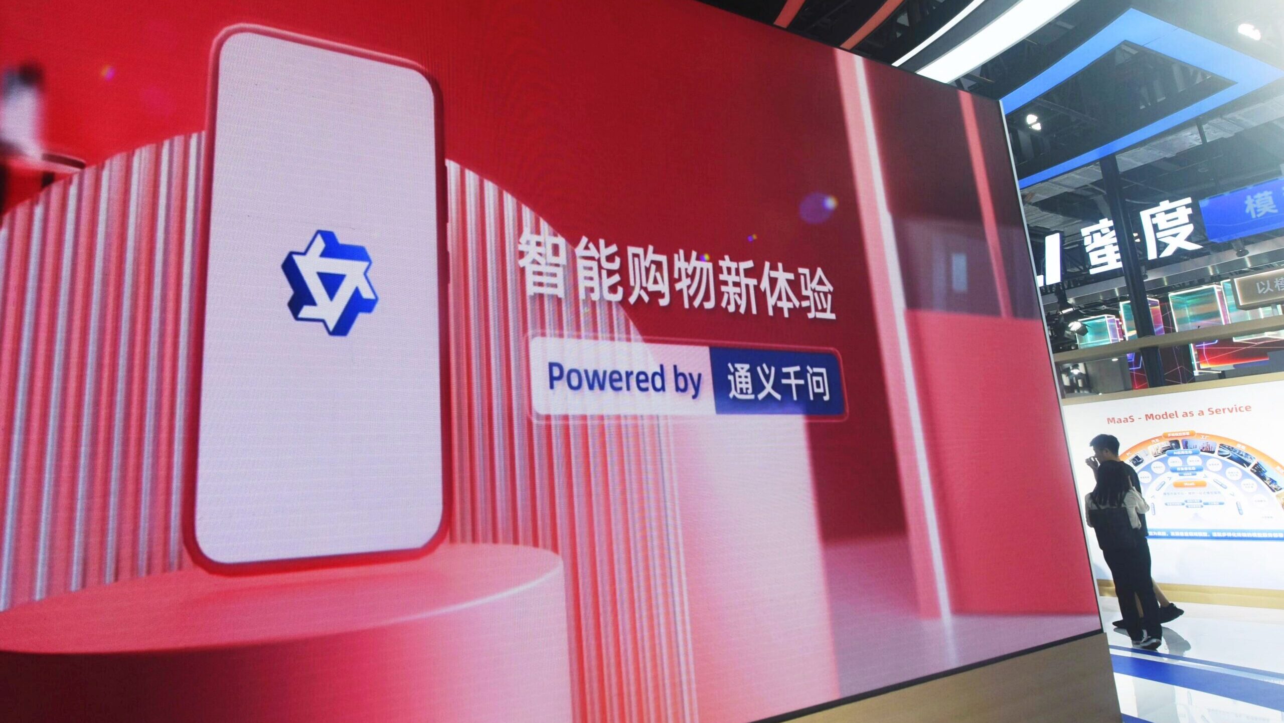 Photo of a Qwen booth at a tech conference.