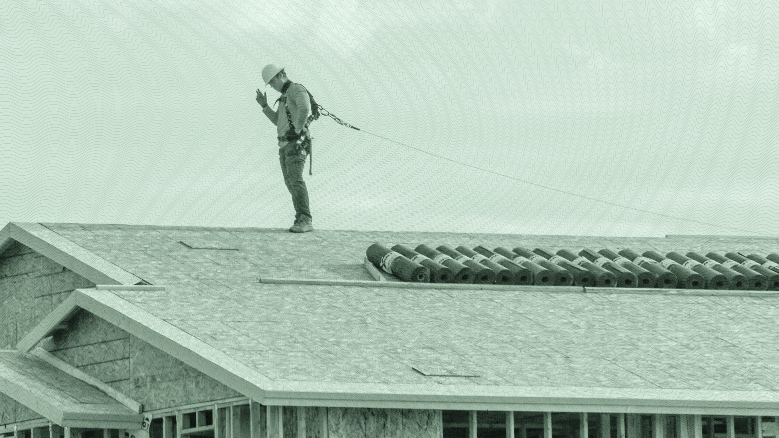 Image of a construction worker on the roof of an unfinished home.