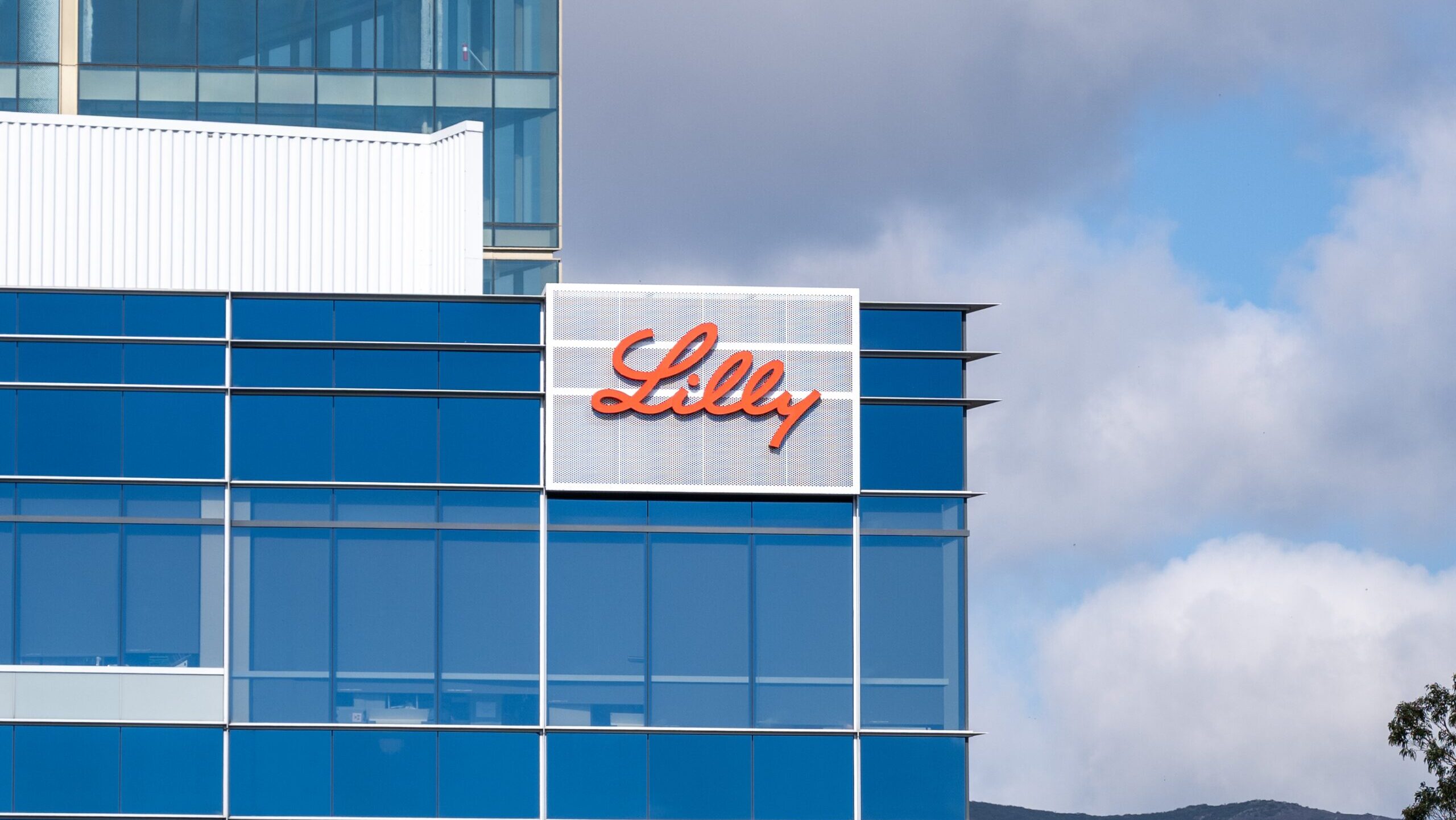 The Eli Lilly logo is shown on the side of a glass office building in San Francisco.