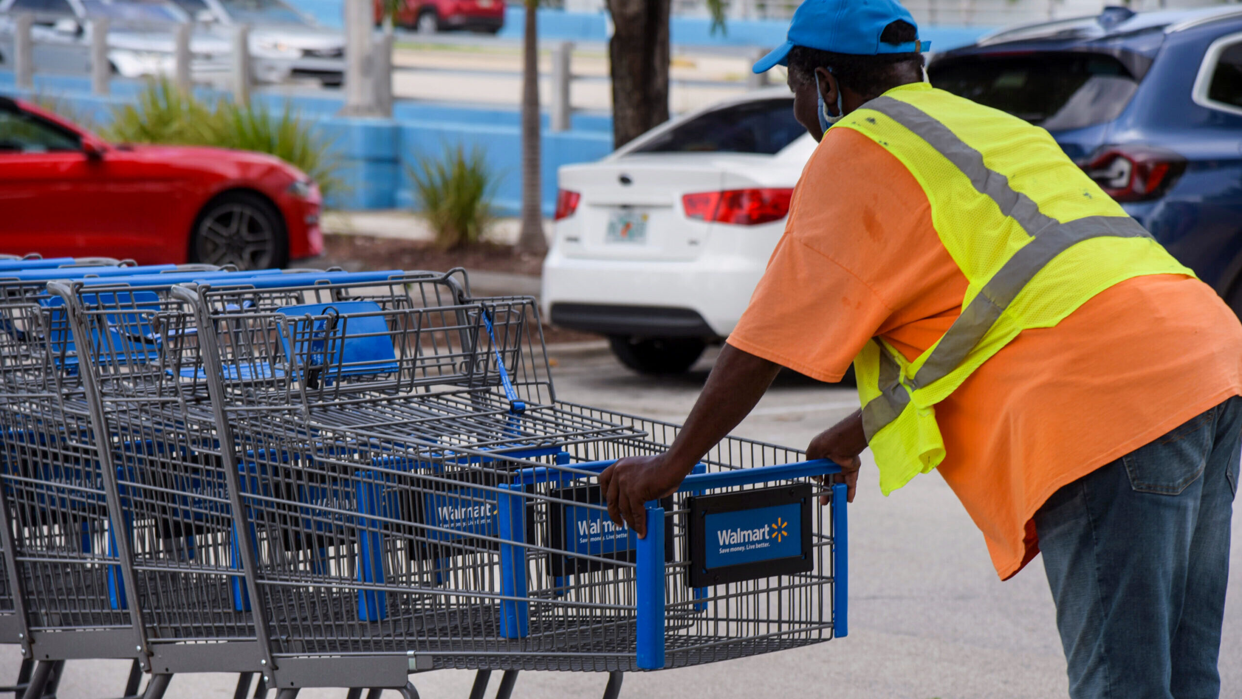 Photo of a Walmart employee pushing shopping carts.