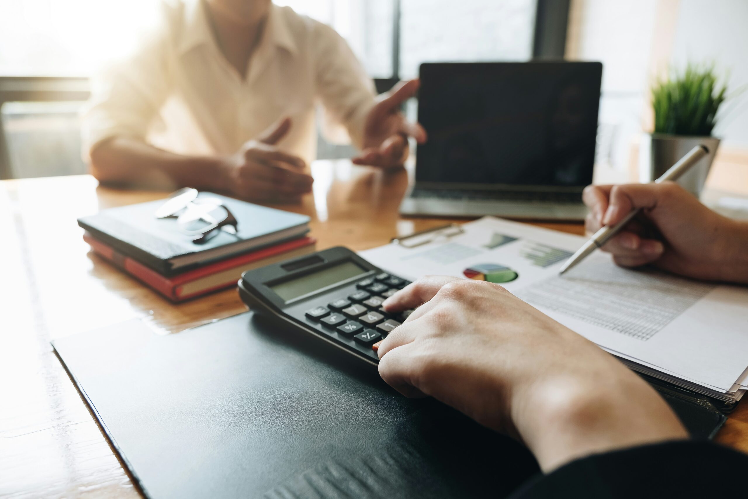 Two people sitting at a desk looking at financial documents.