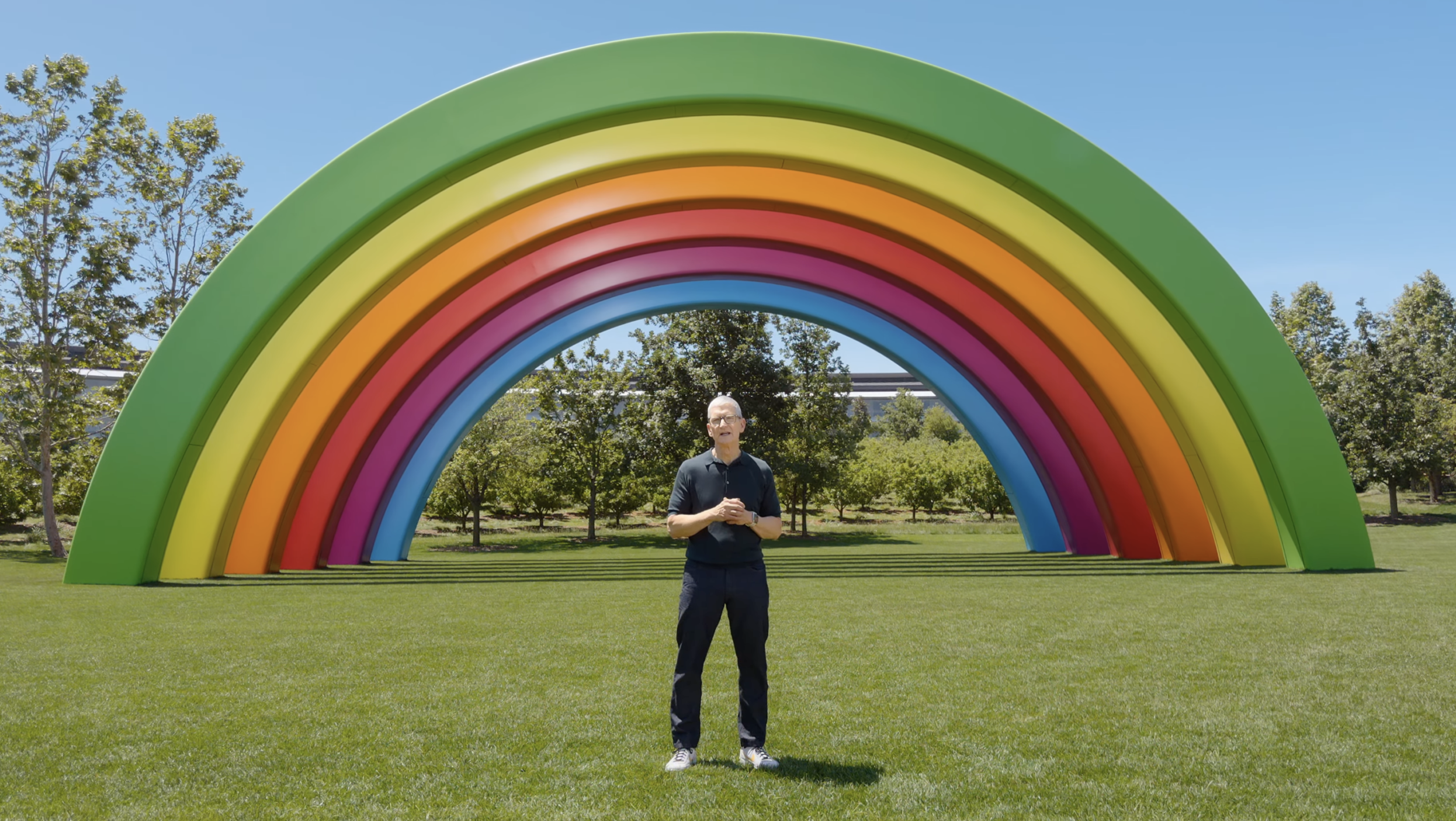 Tim Cook speaks in front of a computer generated rainbow at Apple's Cupertino, California headquarters.