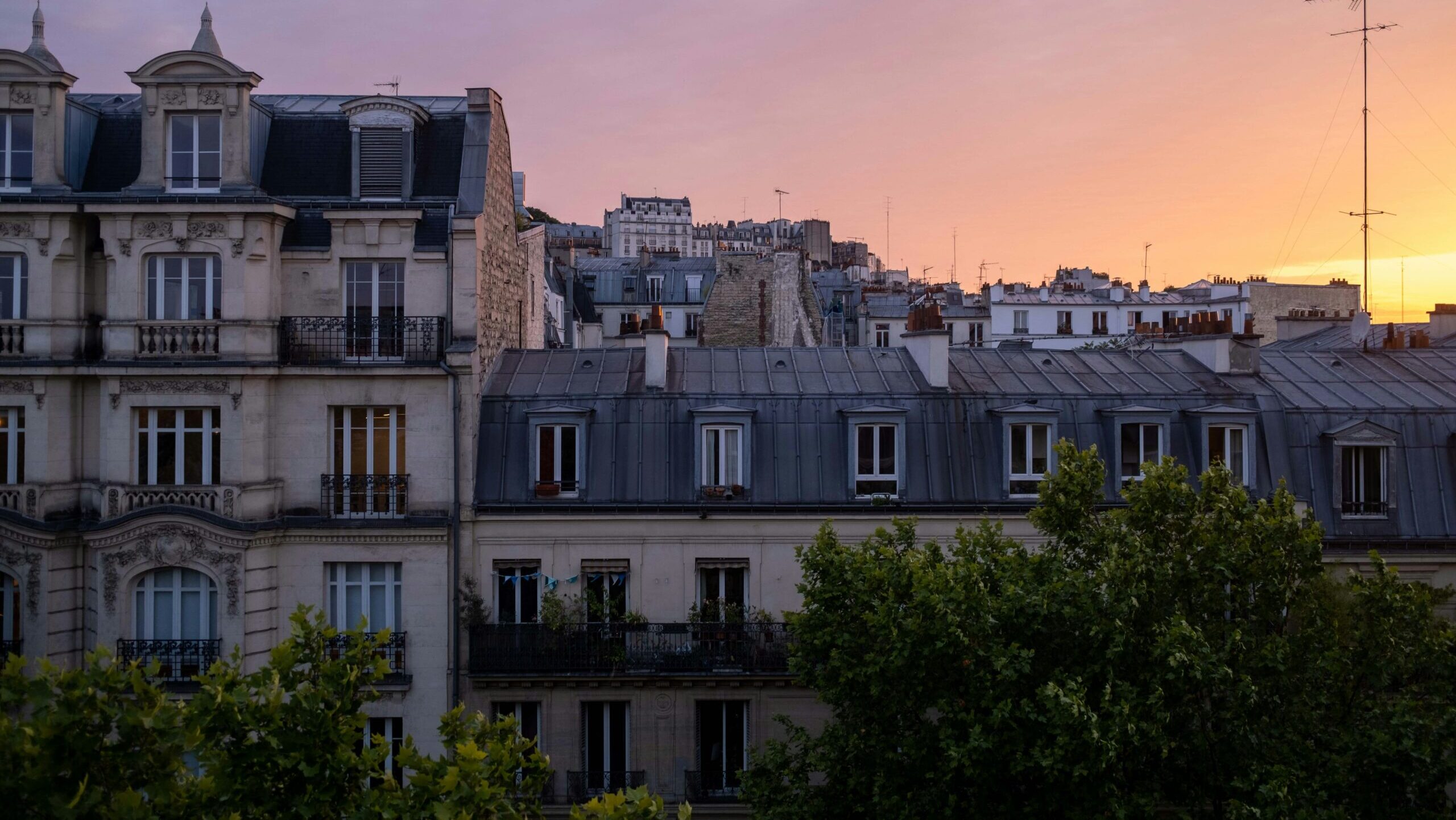 A view of apartment windows in Paris, France at sunset.