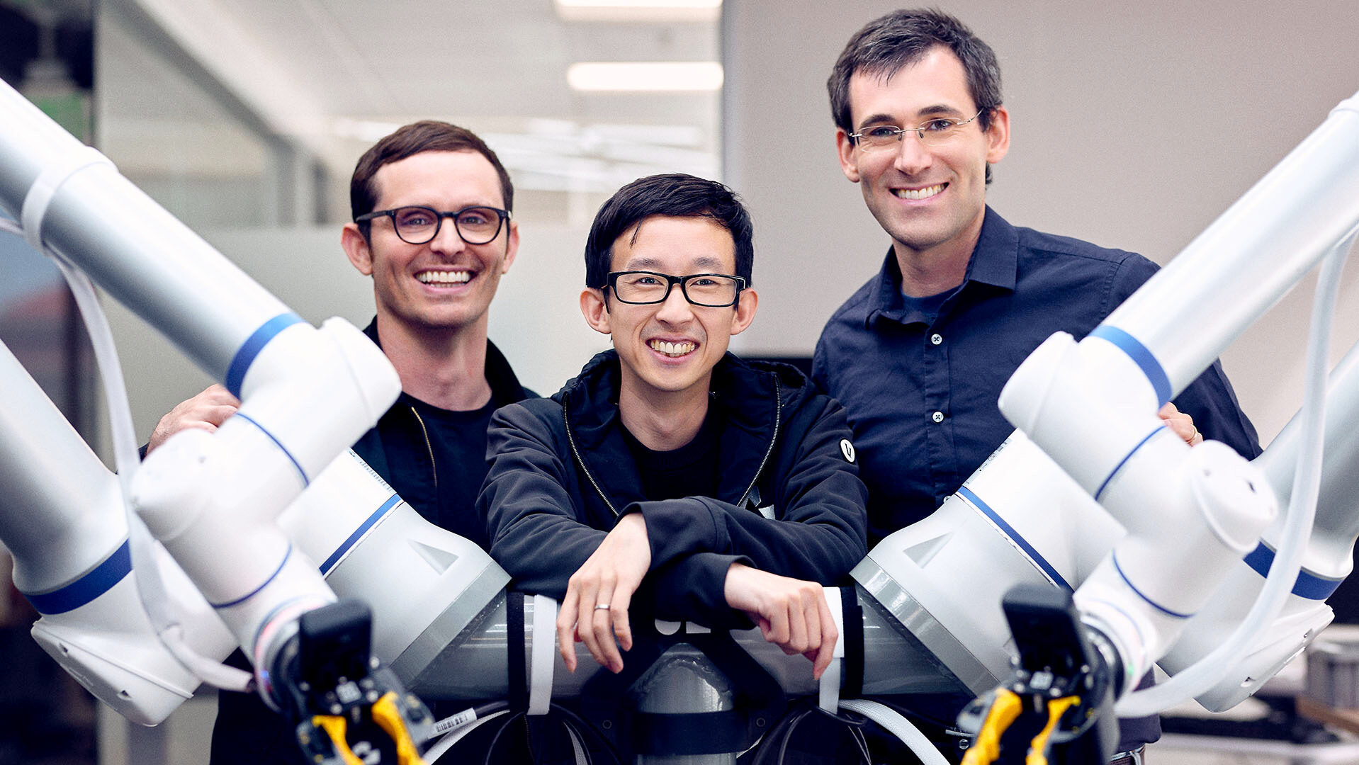 Photo of the Generalist AI founders and robot arms.