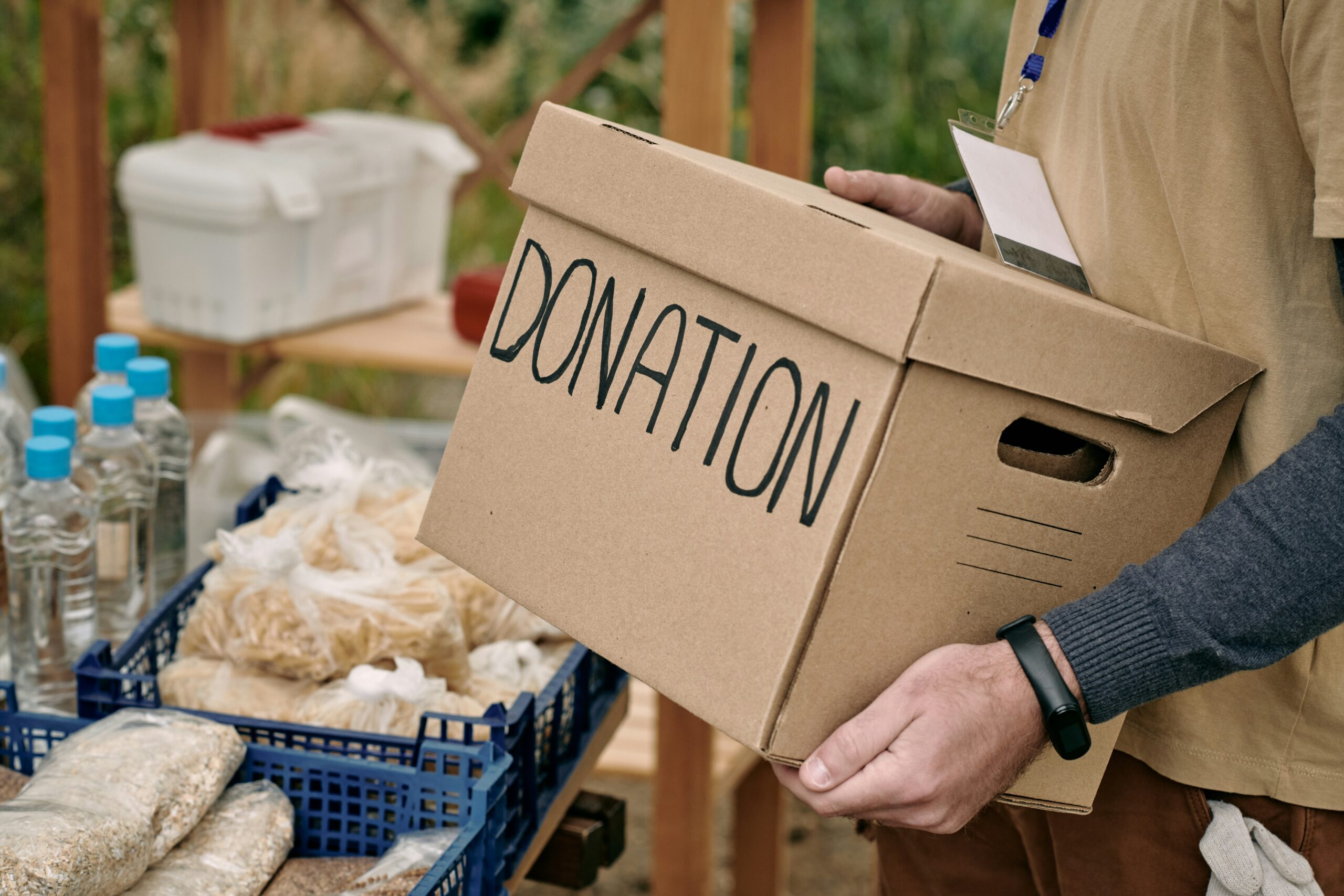 Picture of a person carrying a box with a donation label on it.