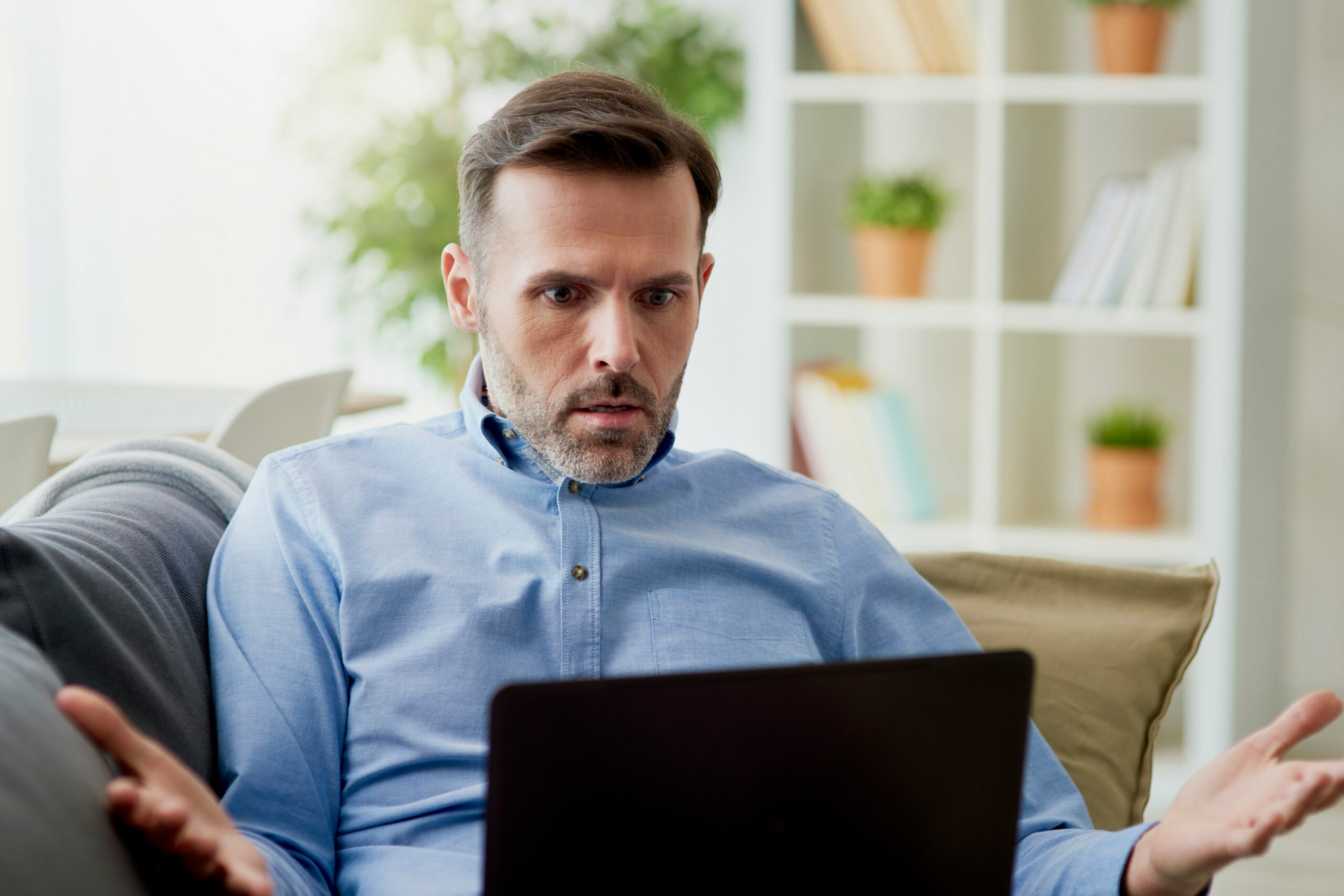 Photo of a man looking confused and holding his hands out to the side.