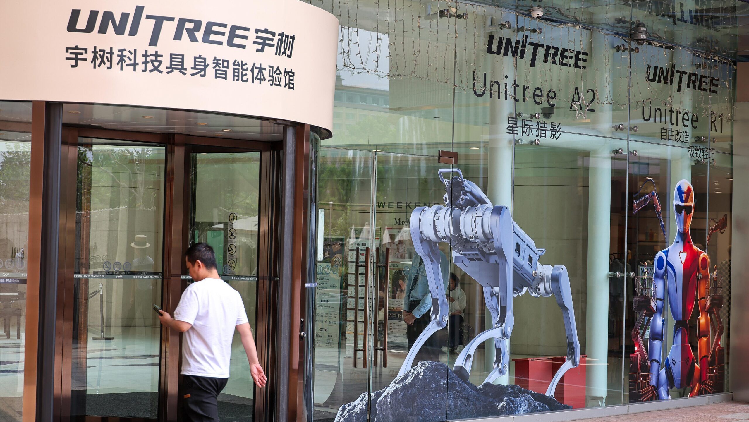 Images of quadripeal and bipedal robots are displayed on a Unitree Robotics office in Shanghai.