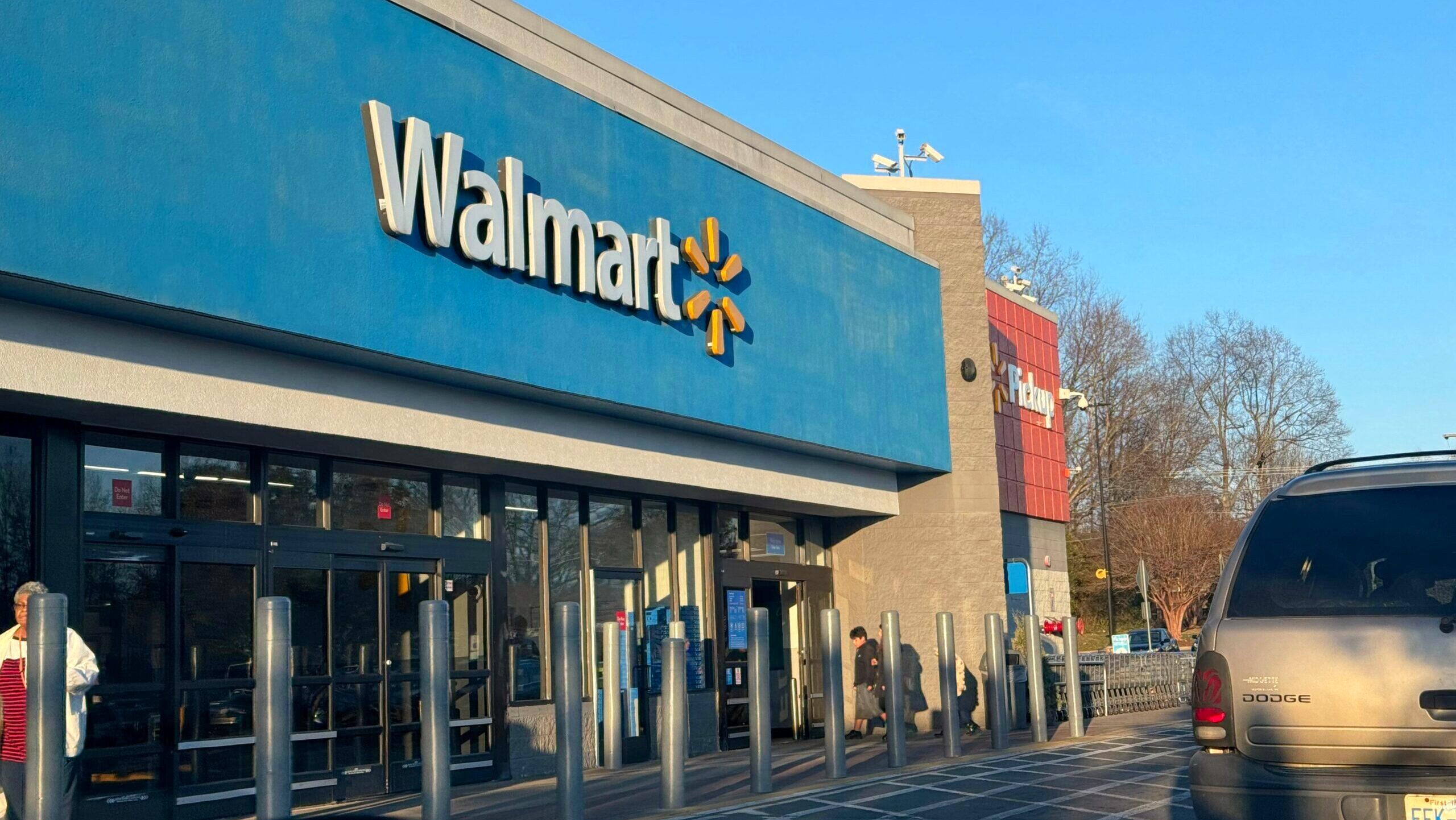 The exterior facade of a Walmart store in Charlotte, North Carolina is shown from a car window view.