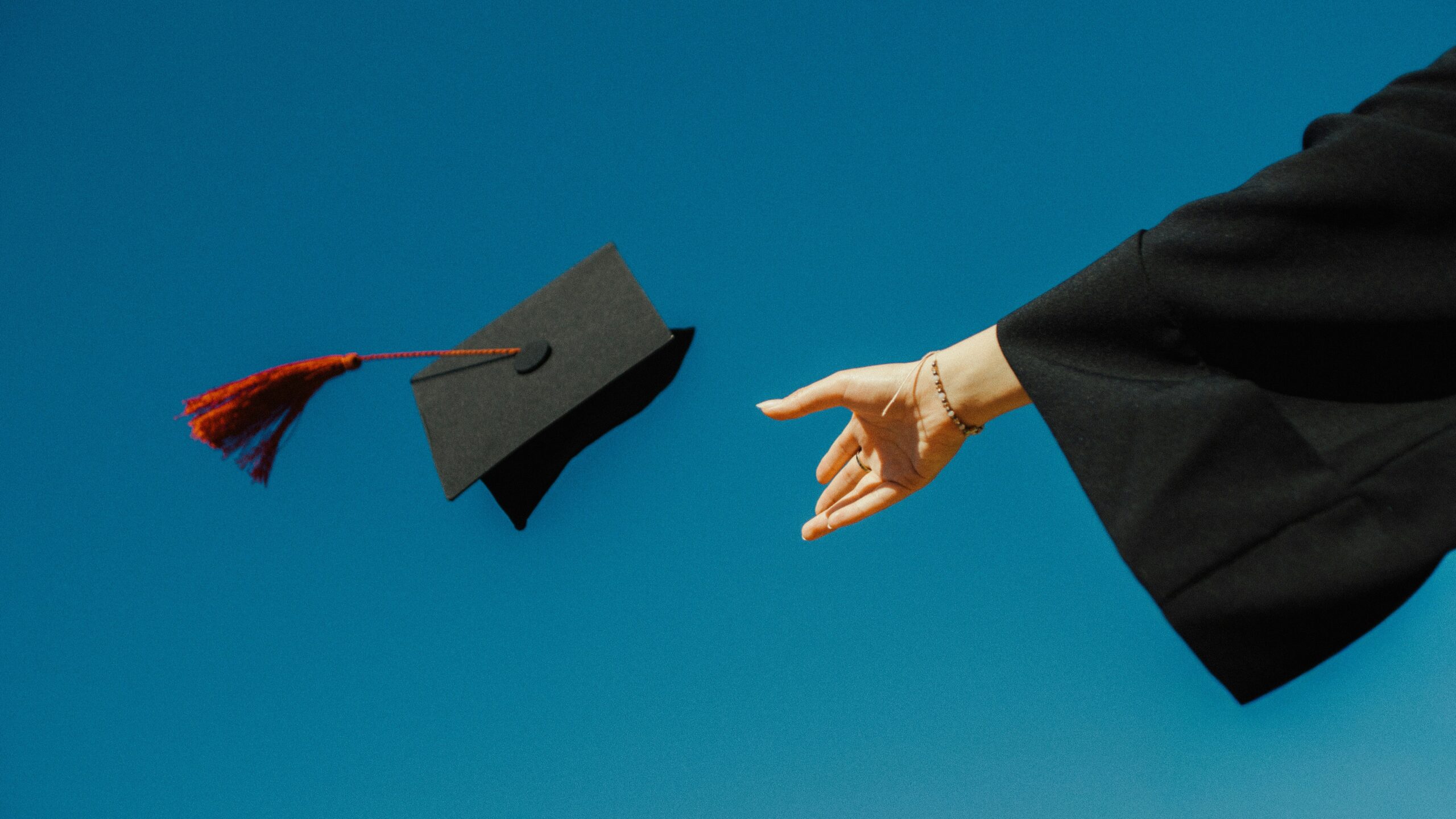 Photo of a person throwing a graduation cap in the air